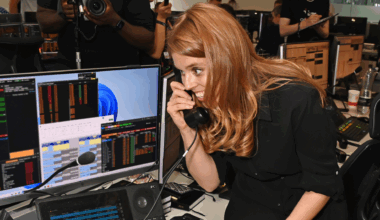 Princess Beatrice wearing a black dress smiling on a phone