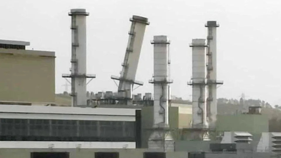 A power station pictured with five chimney's one of them is at an angle due to damage suffered during a storm.