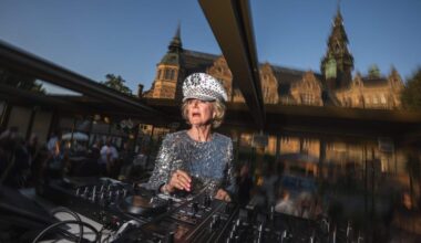81-year-old Madelein Mansson, aka “DJ Gloria”, performs at Josefina, an outdoor summer bar and club in Stockholm, Sweden, on July 18, 2025. She drops the beat and gets her groove on, spinning discs like a pro as her head-to-toe sequins twinkle under the lights: at age 81, DJ Gloria is filling dancefloors across Sweden. (Photo by Jonathan NACKSTRAND / AFP) / TO GO WITH AFP STORY BY PIA OHLIN