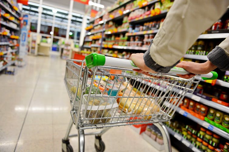 shopper pushing a trolley in a uk supermarket