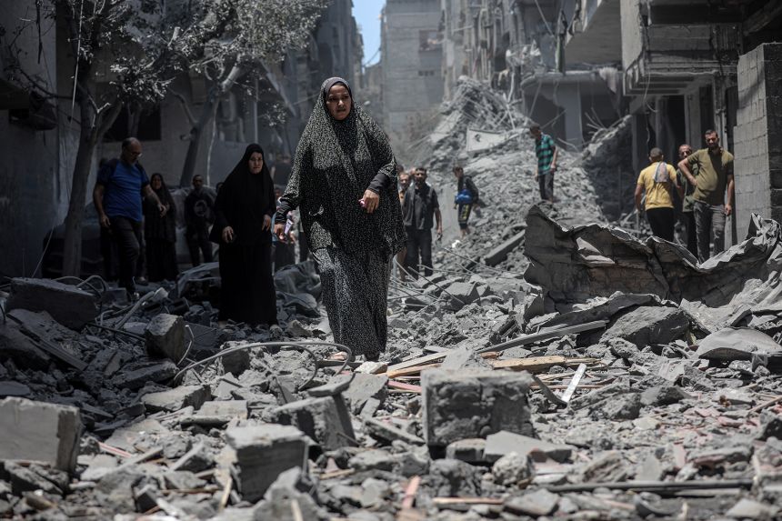 Palestinians walk along the rubble of a demolished residential area following an Israeli airstrike in Gaza City on June 1, 2025.
