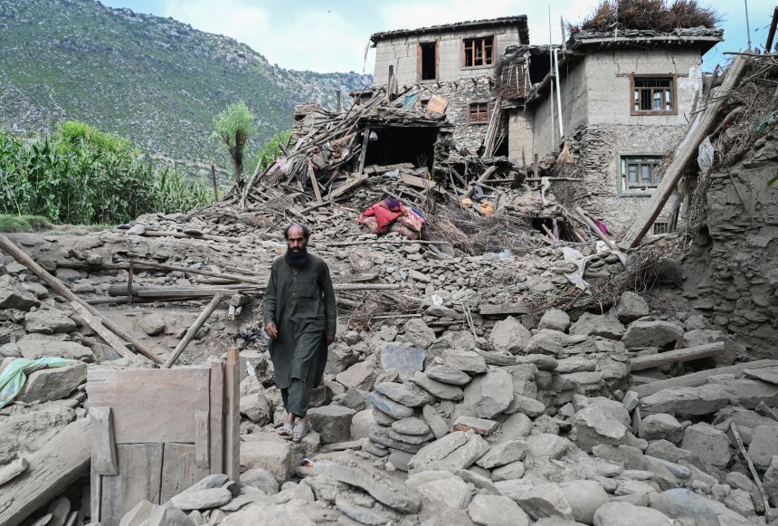 An Afghan man walks past a damaged house following earthquakes in the Mazar Dara village of Nurgal, a district of the Kunar Province, in Eastern Afghanistan, on September 1, 2025.