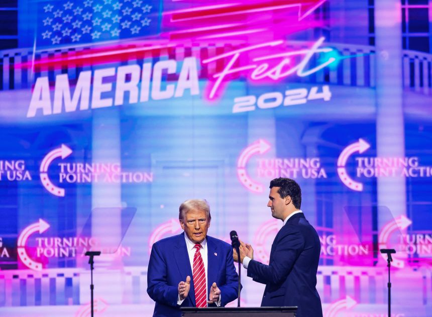 Charlie Kirk (R) appears on stage with US President Donald Trump at America Fest 2024 in Phoenix, Arizona on December 22, 2024.