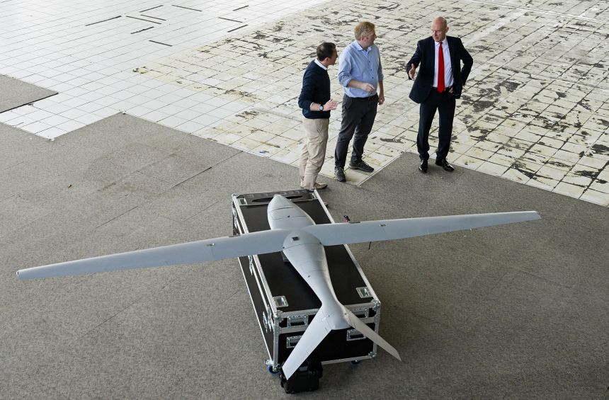 UK Defence Secretary John Healey (R) and Tekever Director of Defence Karl Brew (C) tour a new Tekever military drone production facility, in Swindon, southern England, on September 15, 2025.