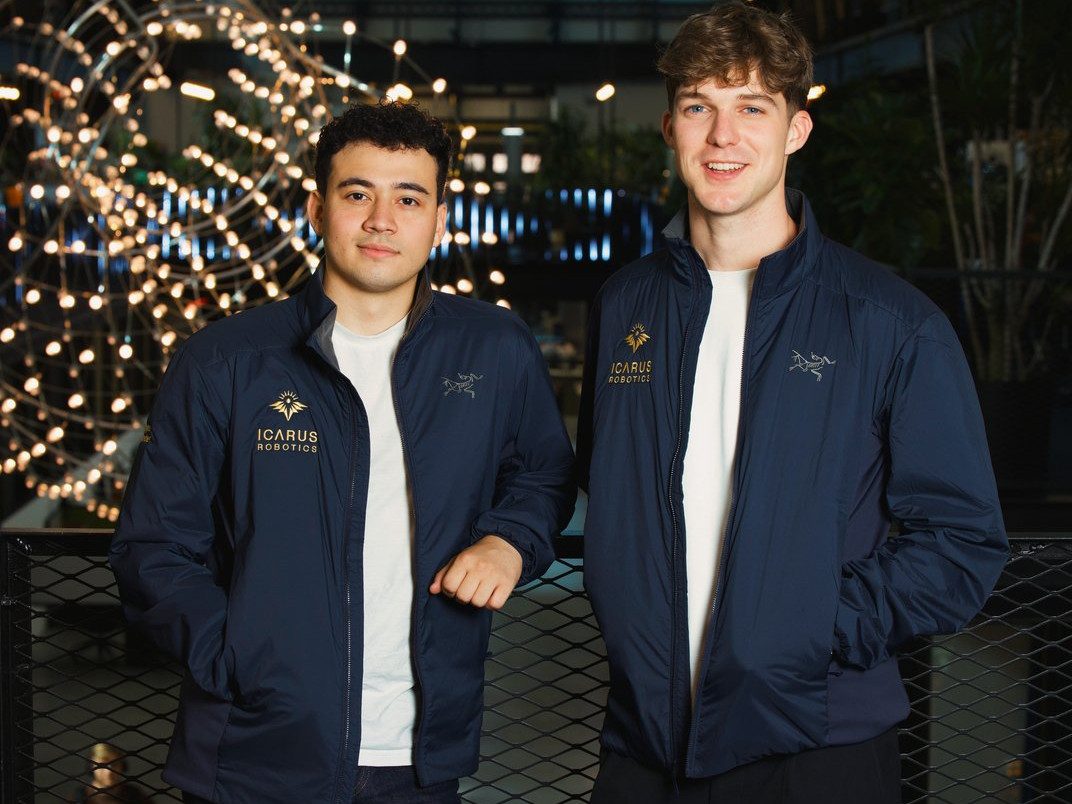 Two young men standing, smiling,