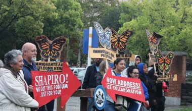 Immigrant advocates hold signs at a rally in Philadelphia