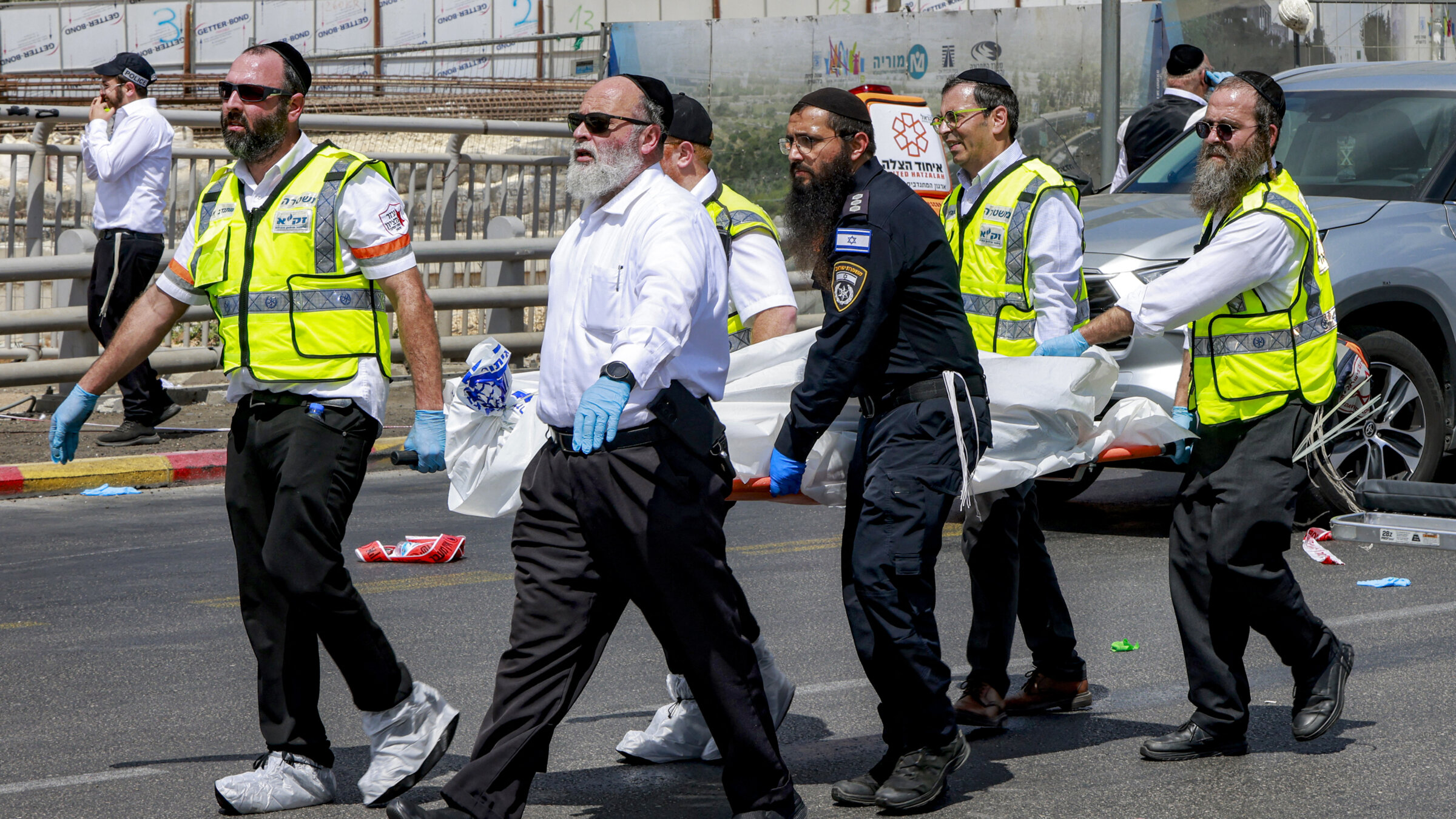 Members of Israel's search and rescue emergency services transport a body from the scene of a shooting at the Ramot road junction in Jerusalem, Sept. 8.
