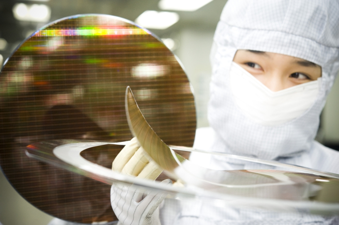 An SK Hynix researcher holds a chip wafer in a company cleanroom