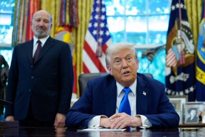 US President Donald Trump announces the Trump Gold Card, an investment immigration program, at the White House on Sept. 19, 2025, while Commerce Secretary Howard Rutnick looks on