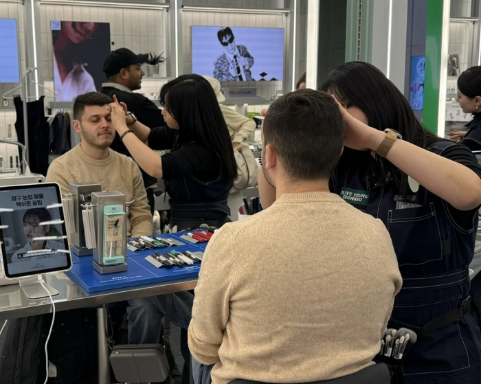 A foreign tourist at CJ Olive Young's Manz Brow Bar, a grooming-focused counter targeting male customers with eyebrow shaping and K-pop-inspired color consultations
