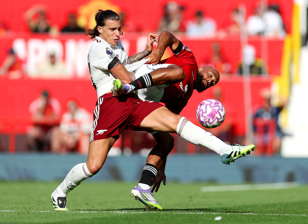 MANCHESTER, ENGLAND - AUGUST 17: Riccardo Calafiori of Arsenal is challenged by Bryan Mbeumo of Manchester United during the Premier League match between Manchester United and Arsenal at Old Trafford on August 17, 2025 in Manchester, England. (Photo by Michael Regan/Getty Images)