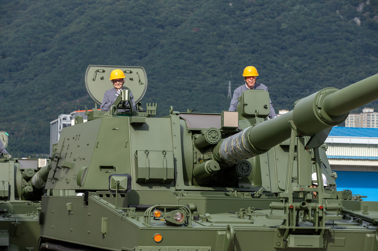 Lois Rae Guin (left), 98, a former US Navy nurse during the Korean War (1950-1953), and Robert Max Martinez, 94, a former US Army sergeant during the war, pose inside a Hanwha Aerospace K9 self-propelled howitzer at the company’s Changwon factory in South Gyeongsang Province (Hanwha Aerospace)