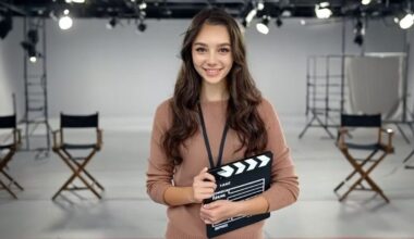 AI actress Tilly Norwood holds a movie clapperboard on a fake set.