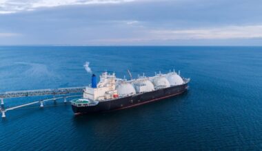 An LNG (liquefied natural gas) carrier is docked at a marine terminal during the offloading process in open waters. (Adobe Stock Photo)