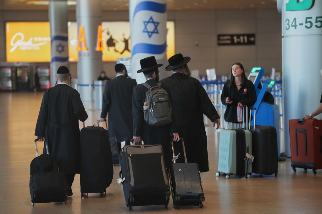 Ultra-Orthodox Jewish men with luggage at Ben Gurion Airport.