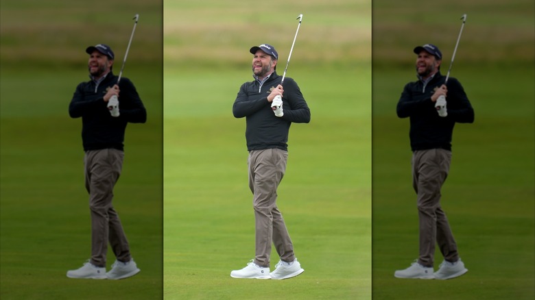JD Vance gurning while in the midst of a clumsy golf swing