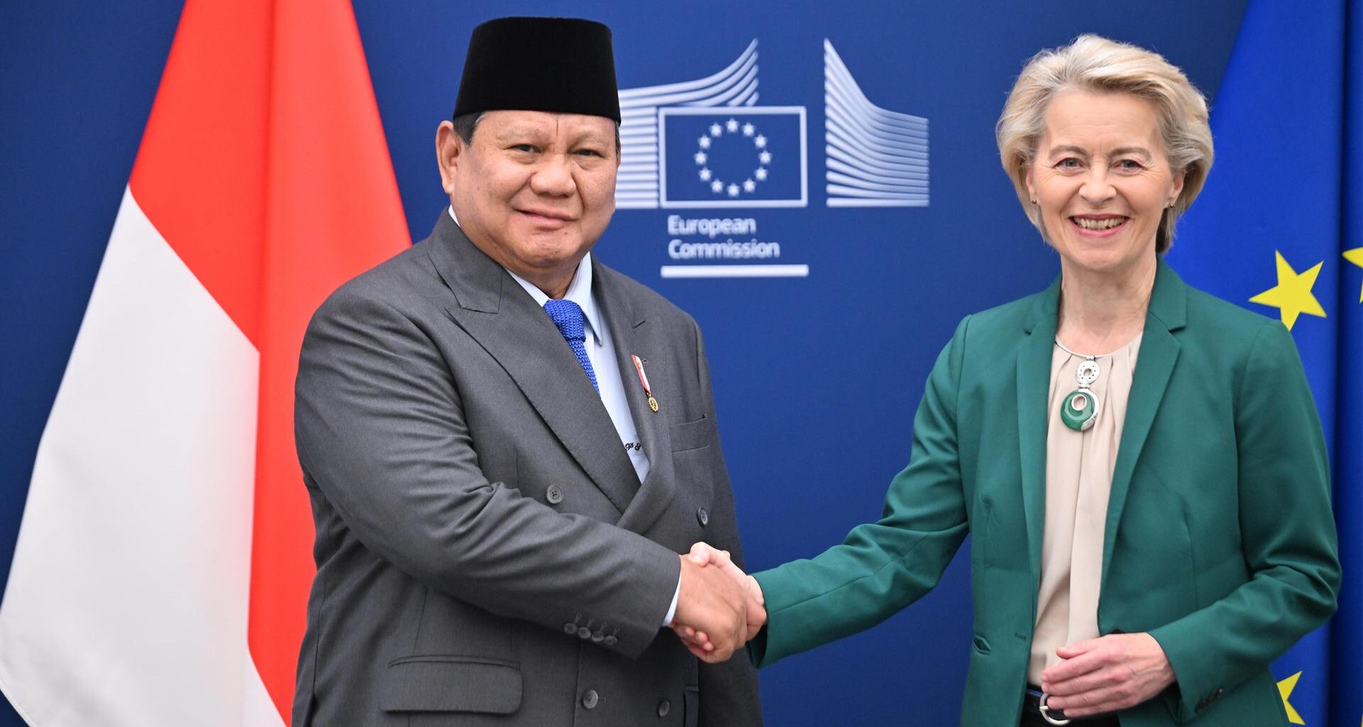 Prabowo Subianto, Präsident von Indonesien, und EU-Kommissionspräsidentin Ursula von der Leyen schütteln Hände vor einer Wand mit dem Logo der EU-Kommission sowie den Flaggen Indonesiens und der EU.