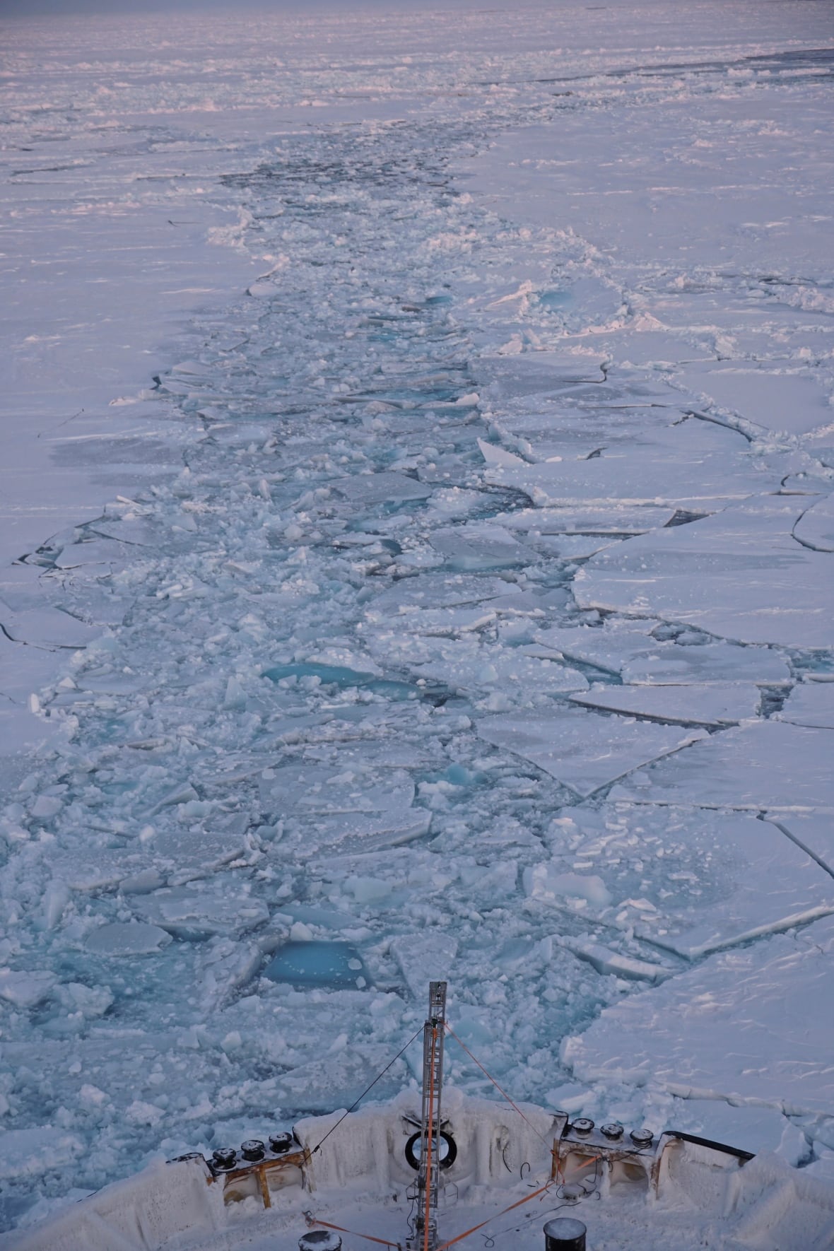 Photo of a ship going through sea ice.