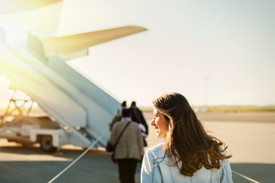 Woman walking toward an airplane at an airport.