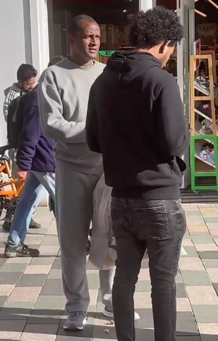 Hadush Kebatu, an alleged murderer, standing on a sidewalk.