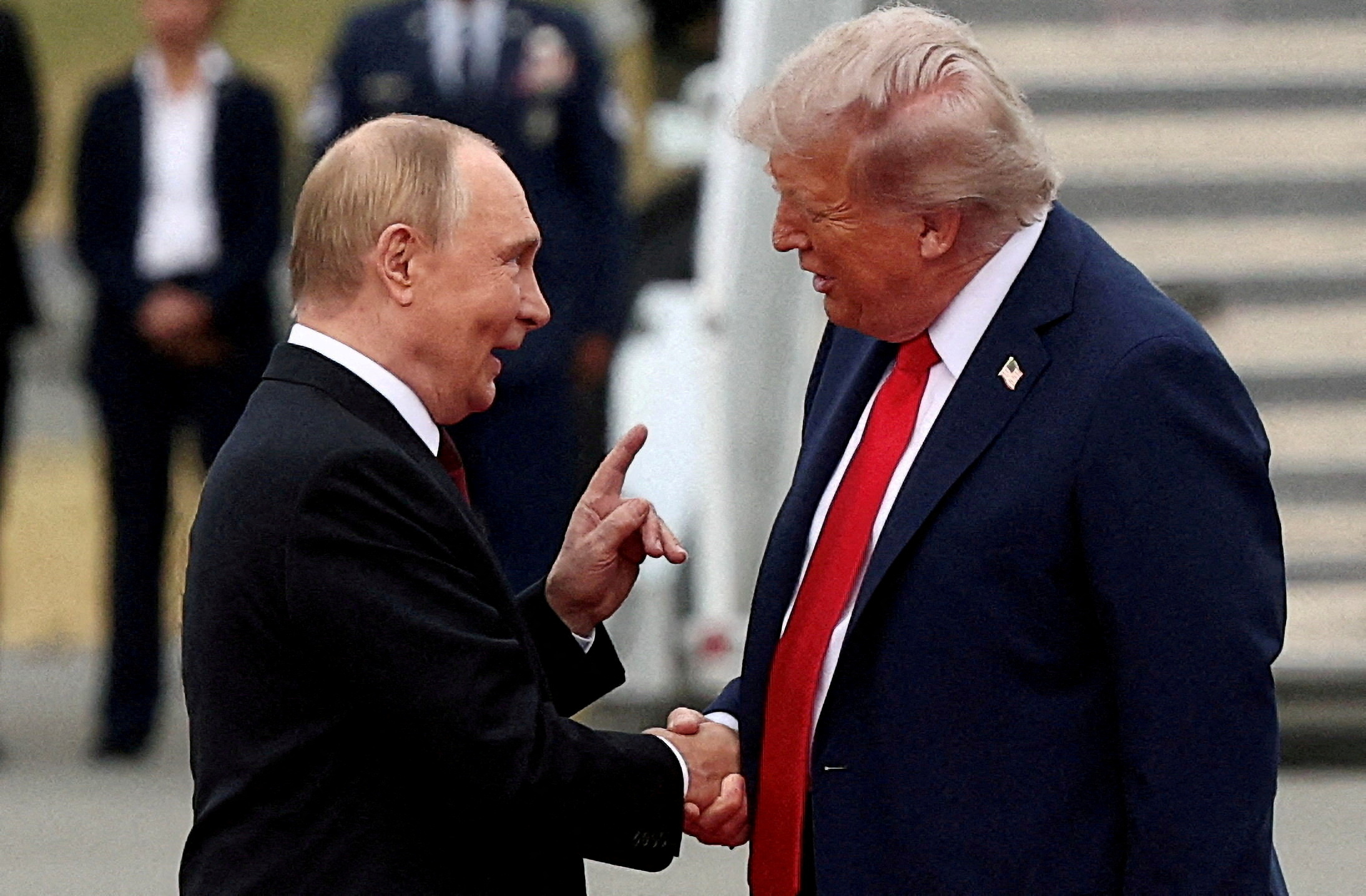 U.S. President Donald Trump shakes hands with Russian President Vladimir Putin.