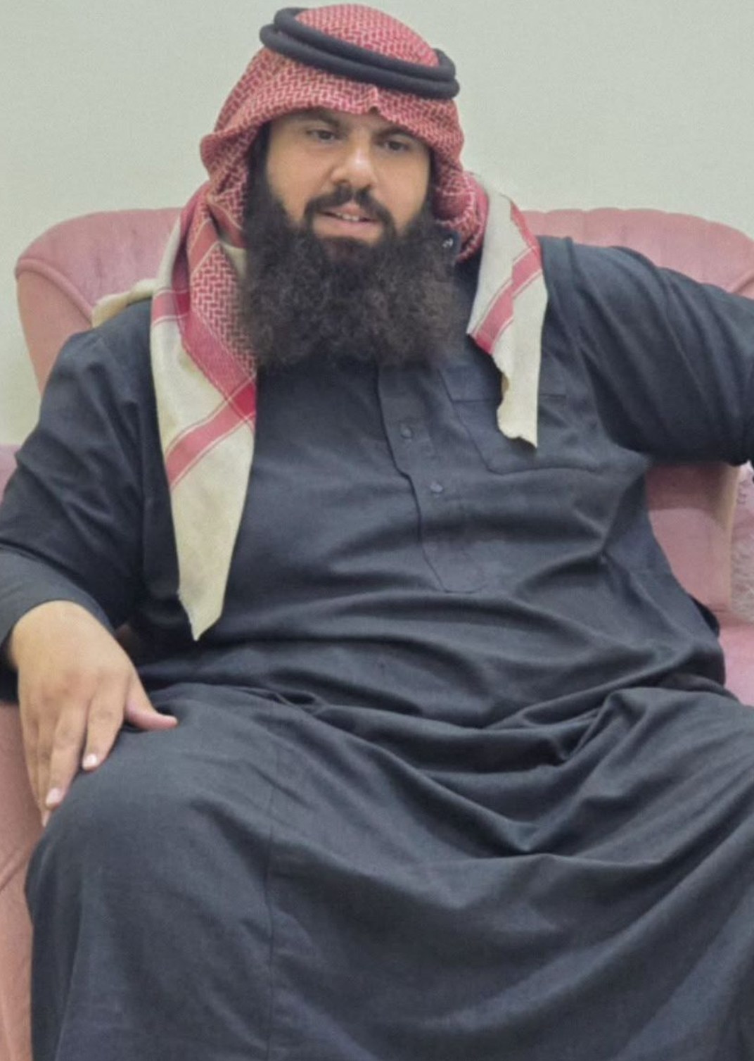 Khaled Al-Masood Al-Badri wearing a black thawb and a red and white keffiyeh.