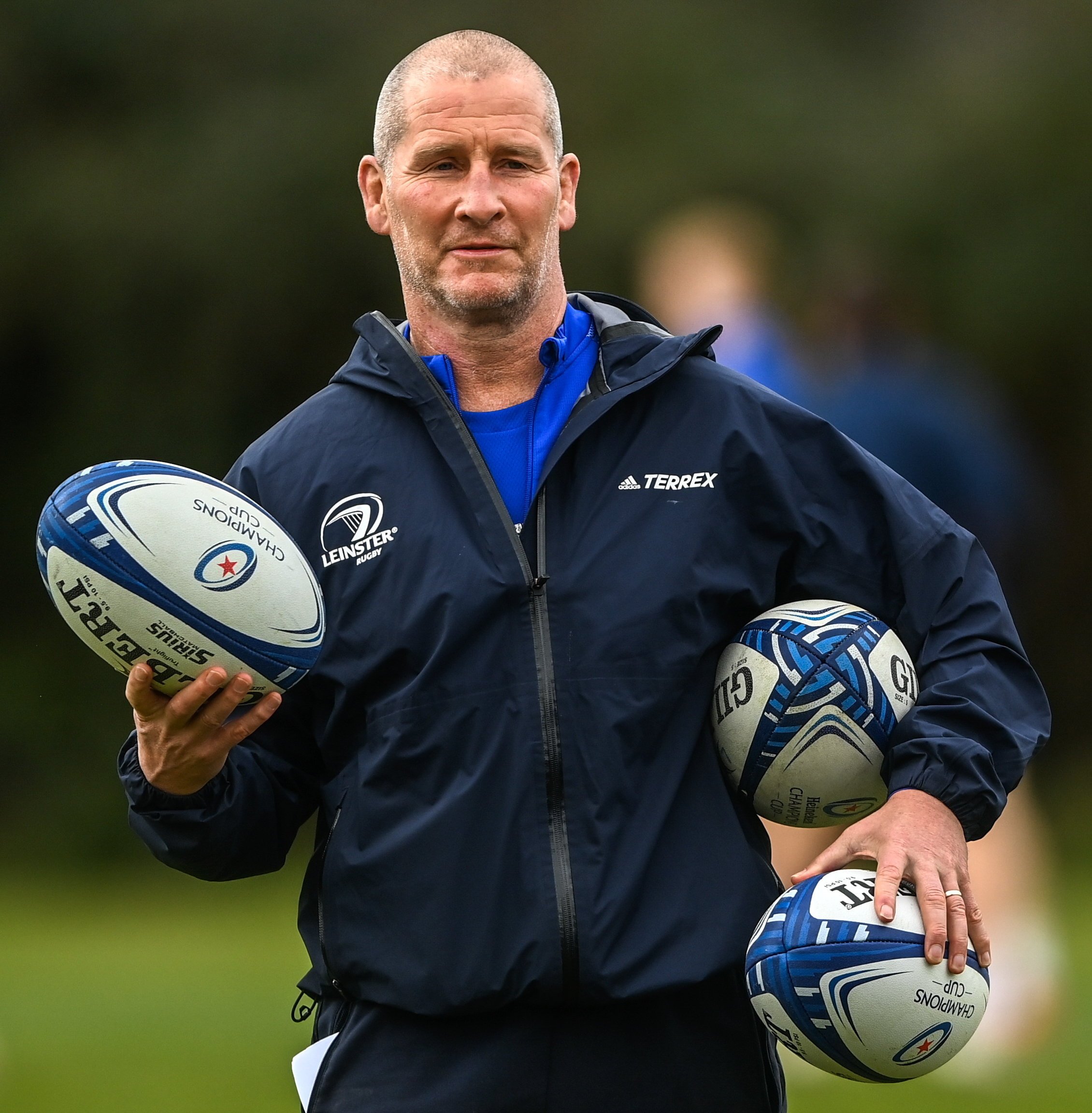 Stuart Lancaster, Senior coach for Leinster Rugby, holding three rugby balls during a training session.