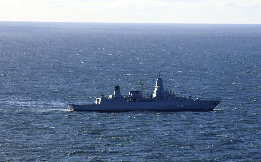 A warship in the middle of the photo at sea.