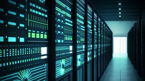 Getty Images A blue and green glow surrounds rows of data centre server racks.

