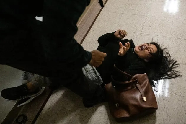 A federal agent pushes the wife of a detained man from Ecuador to the ground on Sept. 25 in New York City. Despite getting continuances on their asylum claims, federal agents are still detaining immigrants who appear for their court dates.