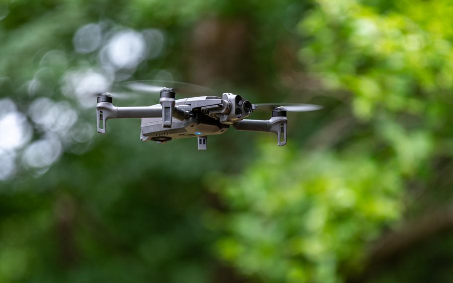 A drone flies in the woods.