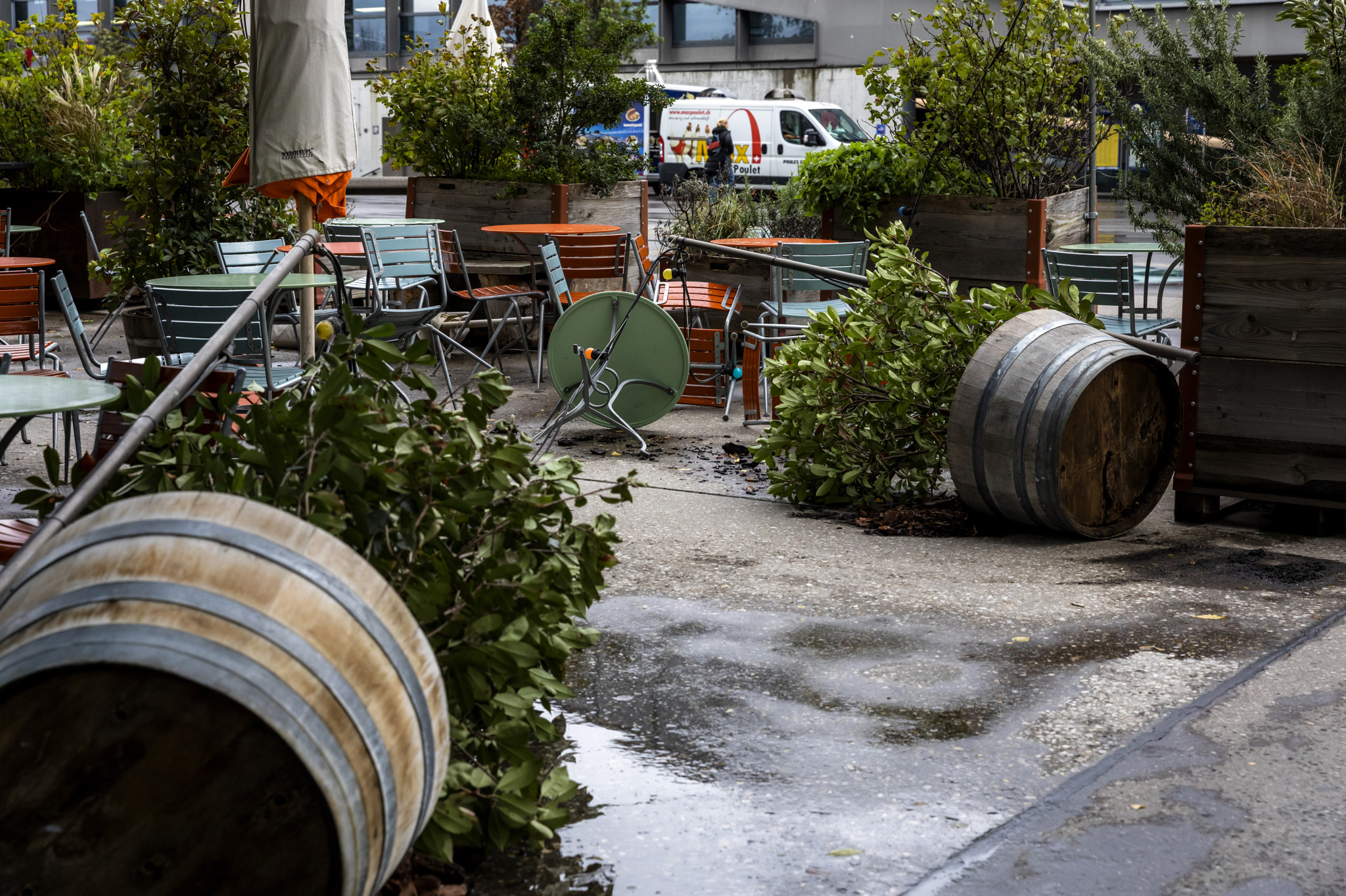 Umgekippte Blumentöpfe und Möbel auf dem Meret Oppenheim Platz in Basel nach Sturm Benjamin, mit sichtbaren Schäden.