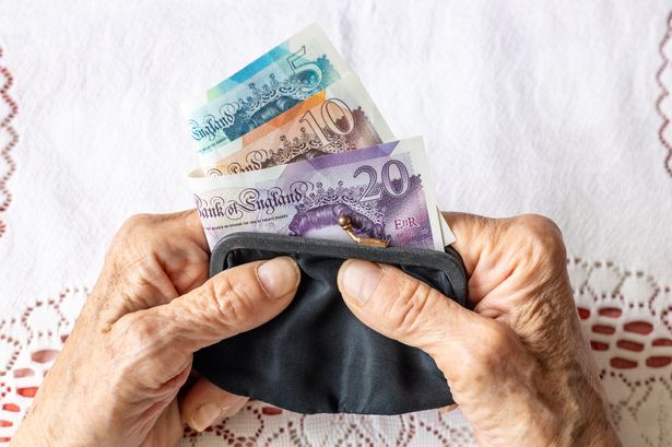 Pensioner holding cash in a purse