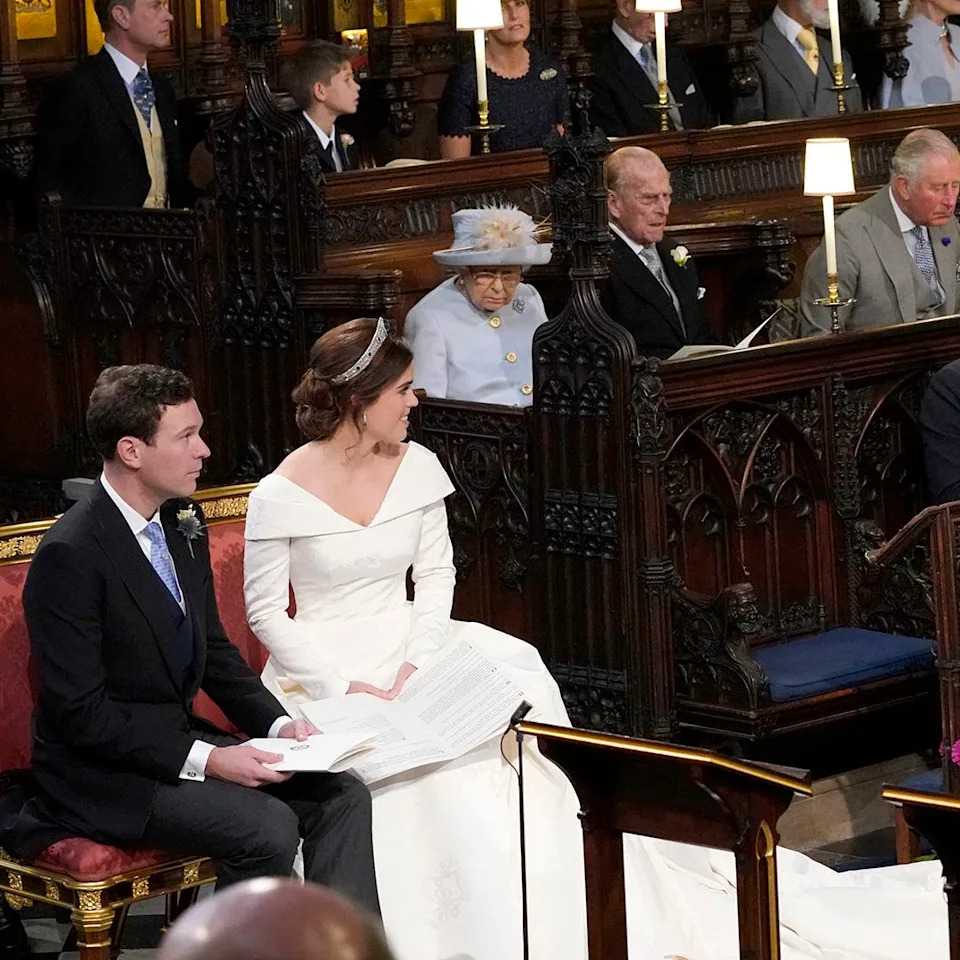  WINDSOR, ENGLAND - OCTOBER 12: Princess Eugenie and her husband Jack Brooksbank, look back towards the Duke of York and Sarah, Duchess of York (seated front) and Queen Elizabeth II, the Duke of Edinburgh, Prince of Wales, the Duke and Duchess of Cambridge, and the Duke and Duchess of Sussex, during their wedding at St George's Chapel in Windsor Castle on October 12, 2018 in Windsor, England. (Photo by Danny Lawson - WPA Pool/Getty Images). 