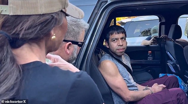 The smiling man appeared to ask Noem to 'let me out' in the footage, filmed by conservative commentator Nick Sortor , but translators have since argued he was actually noting he had 'seen her on the tele[vision]'