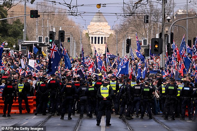 Police officers separate anti-immigration and pro-immigration protesters during a rally in Brisbane on August 31