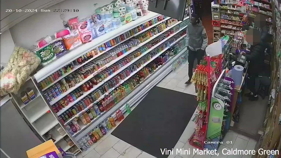 A screen grab taken from CCTV video issued by British Transport Police, shows Mr Majek in a shop on Caldmore Green. The shelves are lined with drink bottles and other products.