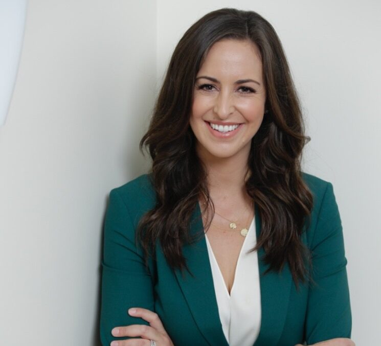 Jesse Draper headshot, in a green blazer