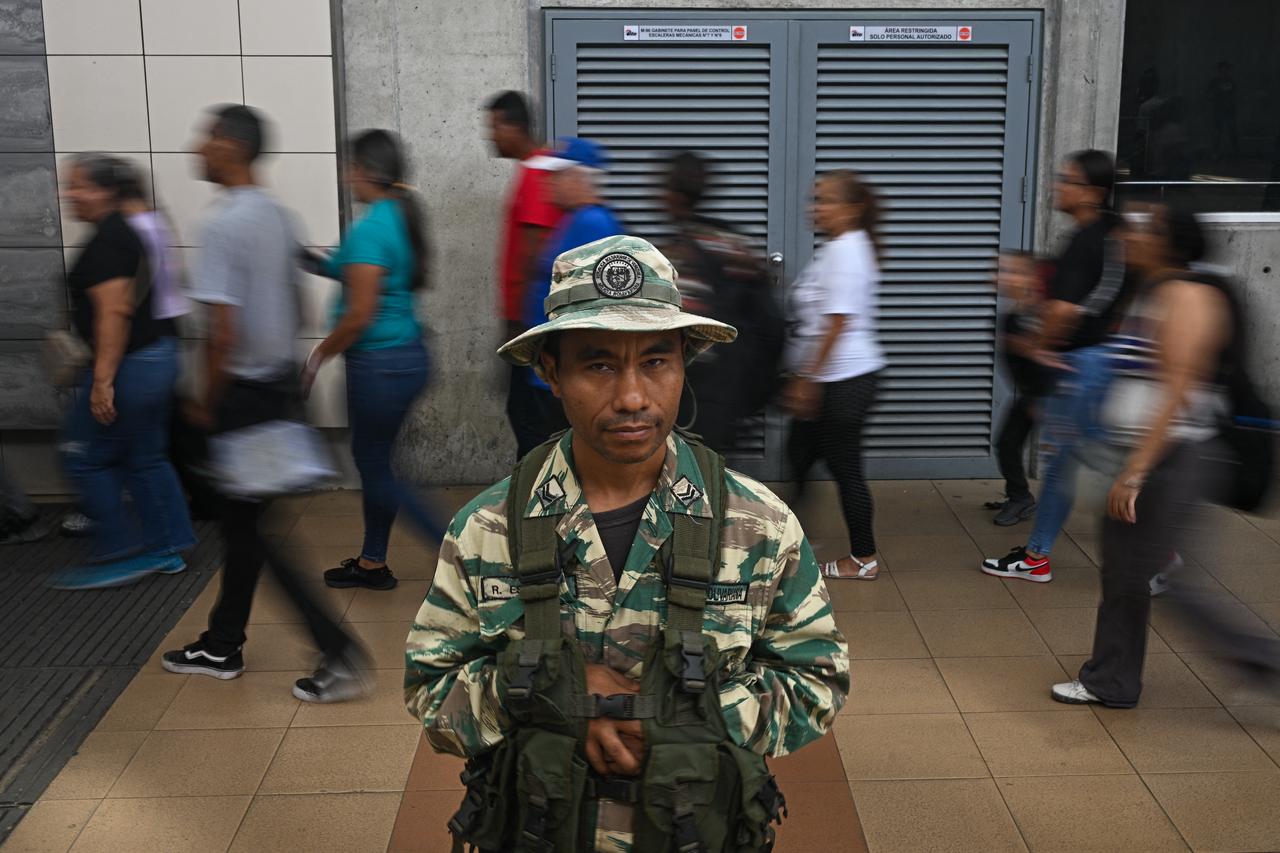 People evacuate a train station behind a Bolivarian militia during a risk reduction drill on natural disasters or armed conflict in Caracas on September 27, 2025. (AFP Photo)