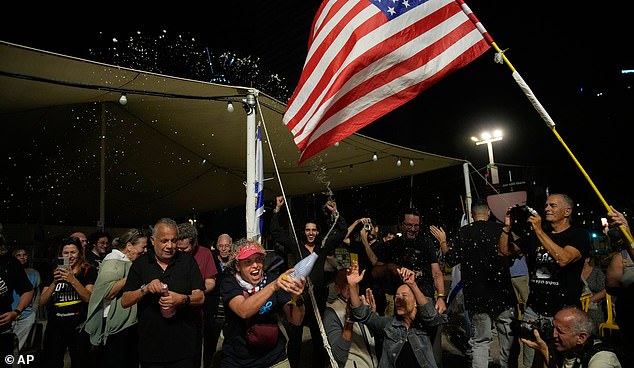 Relatives and supporters of Israeli hostages held by Hamas in the Gaza Strip celebrate after the announcement that Israel and Hamas have agreed to the first phase of a peace plan, as they gather at a plaza known as the hostages square in Tel Aviv, Israel, Thursday, Oct. 9, 2025. (AP Photo/Ohad Zwigenberg)