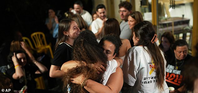 Relatives and supporters of Israeli hostages held by Hamas in the Gaza Strip celebrate after the announcement that Israel and Hamas have agreed to the first phase of a peace plan, as they gather at a plaza known as the hostages square in Tel Aviv, Israel, Thursday, Oct. 9, 2025. (AP Photo/Emilio Morenatti)