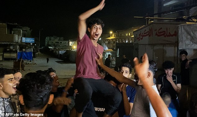 TOPSHOT - Palestinians celebrate in Khan Yunis on October 9, 2025, following news of a new Gaza ceasefire deal. US President Donald Trump announced that Israel and Hamas have agreed to the first phase of a ceasefire in Gaza, after days of indirect talks in Egypt. (Photo by AFP) (Photo by -/AFP via Getty Images)