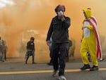 Protesters recover after gas is deployed at the U.S. Immigration and Customs Enforcement facility, Portland, Ore., Oct. 4, 2025.
