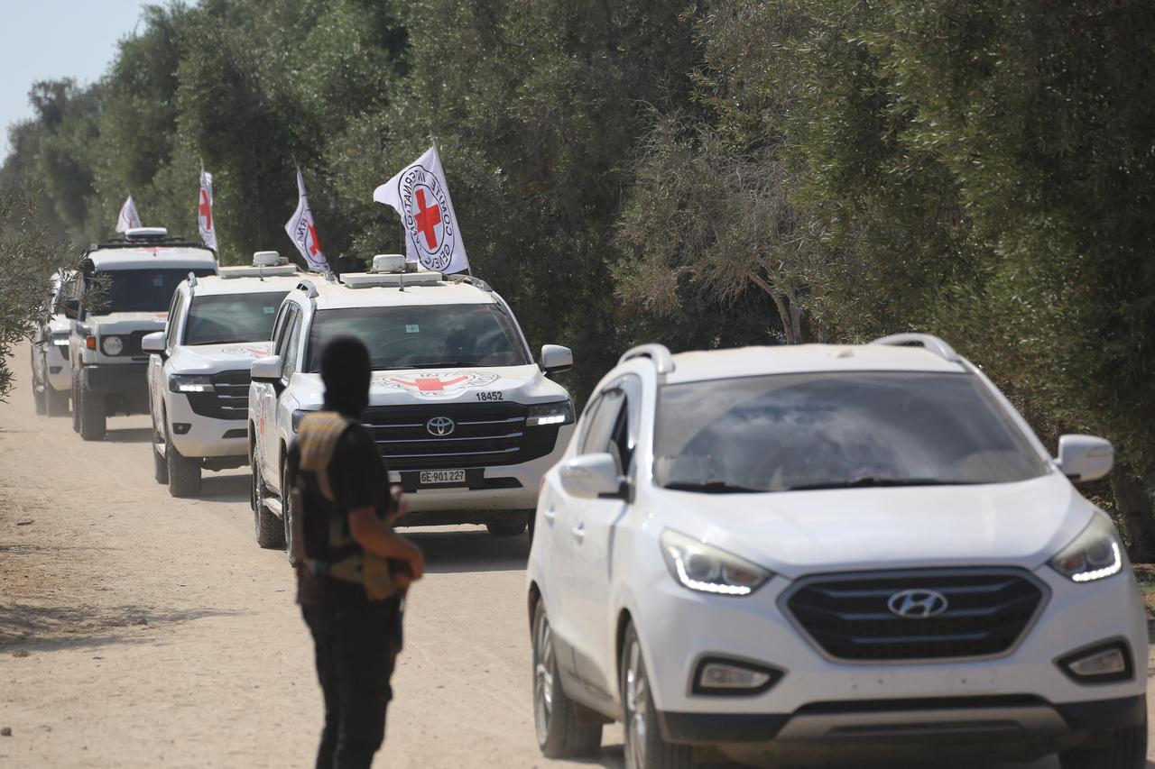 A Qassam Brigades militant watches from the side of the road as vehicles of the International Committee of the Red Cross (ICRC) leave with Israeli hostages in the Gaza Strip, Oct. 13, 2025. (AFP Photo)