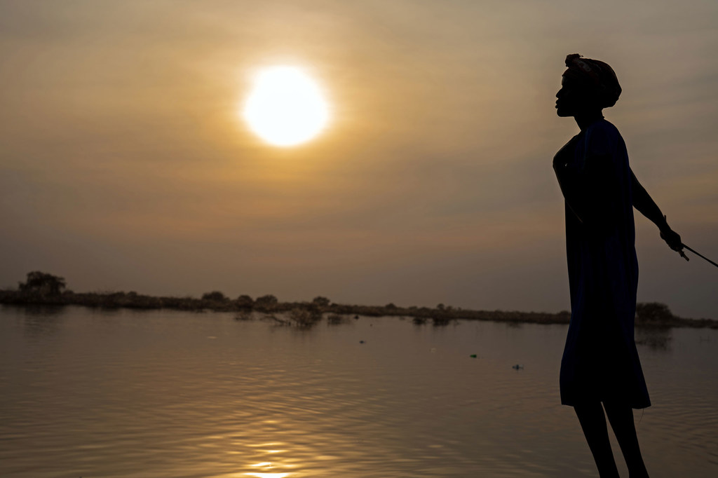 A woman is pictured in front of flooded fields in Bentiu, South Sudan. A woman is pictured in front of flooded fields in Bentiu, South Sudan.