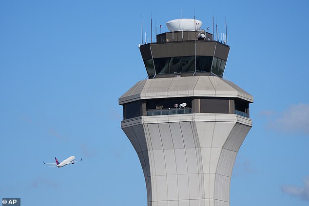 A flight departs past the control tower at Detroit Metropolitan Wayne County Airport Tuesday, Oct. 28, 2025, in Romulus, Mich. (AP Photo/Paul Sancya)