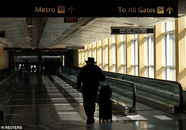 A traveler makes his way to the terminal at Ronald Reagan Washington National Airport, during a government shutdown, in Arlington, Virginia, U.S., October 31, 2025. REUTERS/Kevin Lamarque