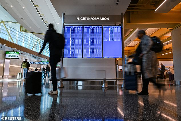 Travelers walk through the airport as the U.S. government shutdown enters 31st day in Washington, DC, U.S., October 31, 2025. REUTERS/Annabelle Gordon