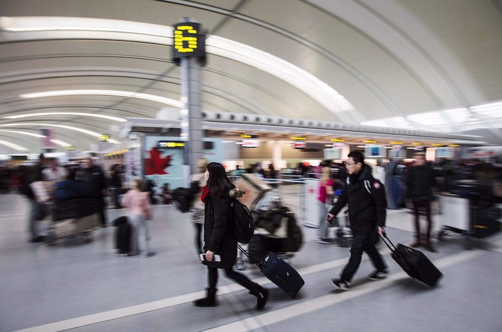 People carry luggage at Toronto Pearson International Airport, one of the federal assets considered most valuable according to a government report. FILE: Friday December 20, 2013. Source: THE CANADIAN PRESS/Mark Blinch