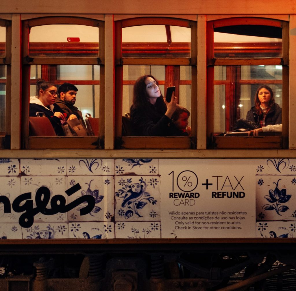 Photo: A woman watches her phone at night in a historic tram. Porto, Portugal, February 03, 2020. Credit: Jean Baptiste Premat / Hans Lucas.